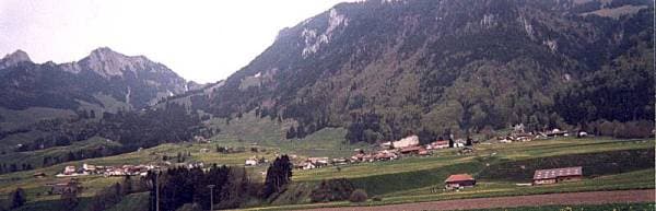 La Dent de Broc, la Dent du Chamois, le col de la Forclaz, le Bourgo, le Vanil-du-Paradis et le Vanil-Blanc, vus depuis la plaine des Auges ; en bas à droite, les fermes de « Champ de l'Auge » (photo Jean Pharisa, mai 1999).