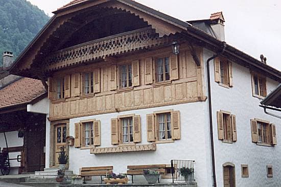 Maison villageoise remarquablement conservée, façade en bois sculpté typique de la Gruyère.